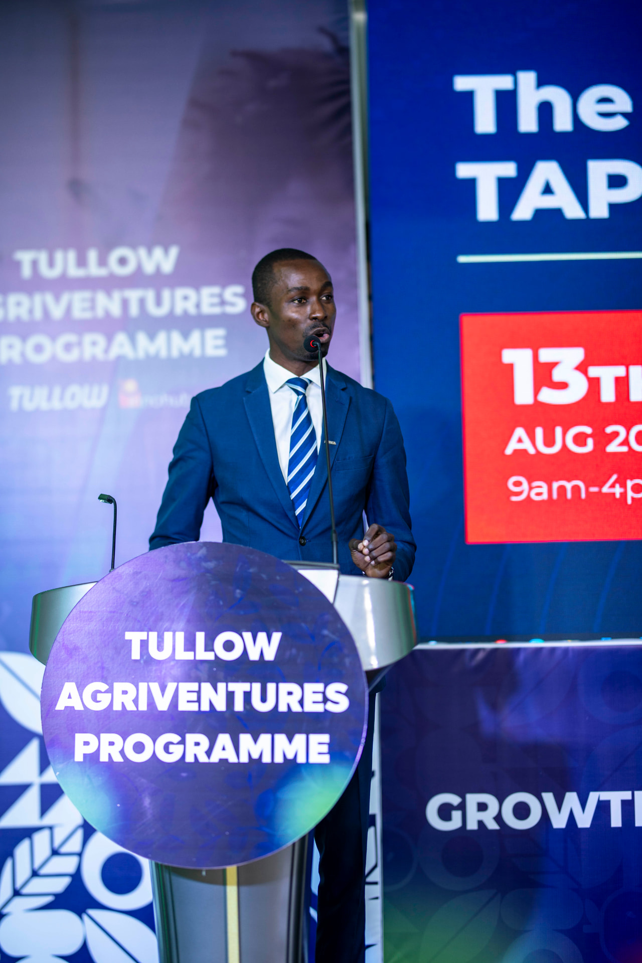 King David Amo hosting at a podium branded Tullow Agriventures Programme